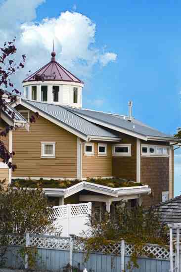 The lighthouse windows provide natural light and ventilation. Solar energy generates some of the home's electricity. The metal roof collects nontoxic rainwater-runoff, and vegetation on the green roof captures and diverts stormwater.